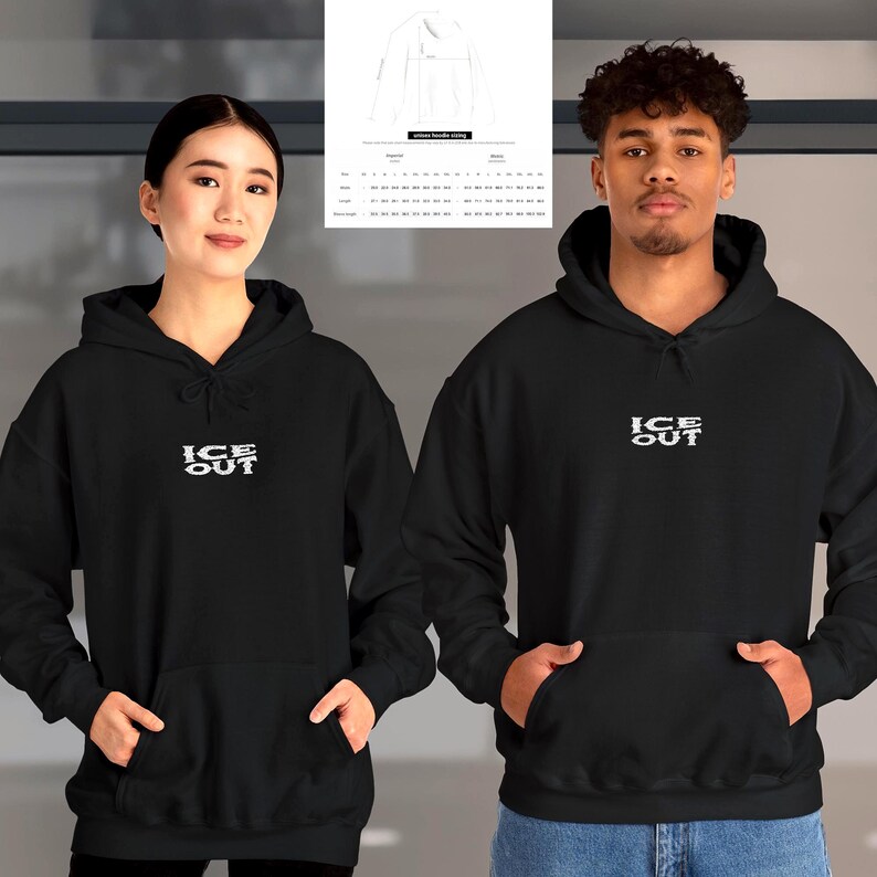 Puede incluir: Dos personas con sudaderas negras con el texto blanco "ICE OUT". Las sudaderas tienen capucha con cord&oacute;n y un bolsillo delantero. Una tabla de tallas es visible en el fondo.