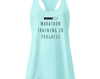 Puede incluir: Camiseta sin mangas azul claro con el texto negro "MARATHON TRAINING IN PROGRESS" y una barra de progreso. Perfecta para entrenamientos de maratón, ofrece comodidad y transpirabilidad.