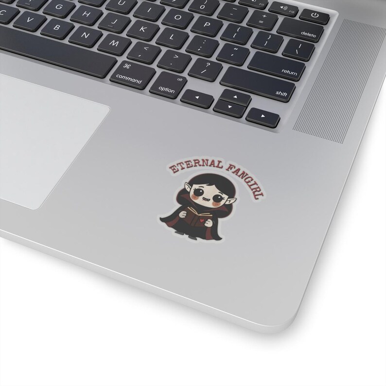 Sticker shaped like a black Puerto Rico license plate with the word "Bayamón", Isla del Encanto phrase, and Puerto Rican flags on both sides. 2in sticker with transparent outline on a laptop for reference.