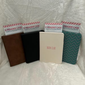 Puede incluir: Cuatro fundas para lectores electrónicos en diferentes colores y patrones. Las fundas están hechas de cuero, tela y tienen un cierre de cremallera. Las fundas están etiquetadas como "E-Reader Case" y una funda tiene el texto "Book Club" impreso en ella.