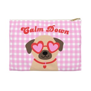 Puede incluir: Una bolsa con cremallera con estampado de cuadros rosas y blancos con un pug de dibujos animados con gafas de sol en forma de corazón. El texto "Calm Down" está escrito en rojo en la parte superior. La bolsa tiene una cremallera dorada.