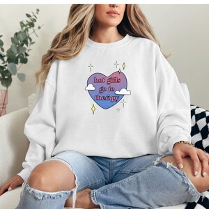 Może przedstawiać: Biała bluza z nadrukiem w kształcie różowego i niebieskiego serca z napisem "hot girls go to therapy".