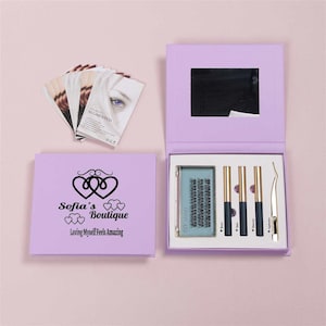 May include: A lavender box with a mirror and a set of false eyelashes, tweezers, and glue. The box has a logo that says "Sofia's Boutique" and "Loving Myself Feels Amazing".