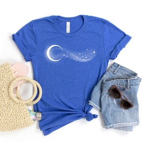 May include: A royal blue t-shirt featuring a white crescent moon and a trail of stars design.
