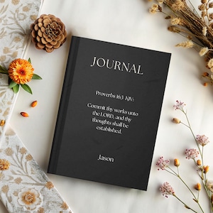 May include: A black journal with the word "JOURNAL" in white lettering. The journal includes the text "Proverbs 16:3 KJV: Commit thy works unto the LORD, and thy thoughts shall be established." and the name "Jason".