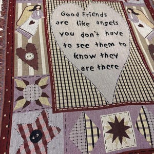 May include: A woven throw blanket with a patchwork design. The blanket features a large heart with the text "Good Friends are like angels you don't have to see them to know they are there." The color palette includes burgundy, lavender, and cream.