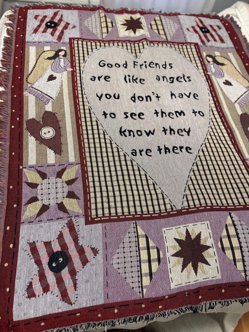May include: A woven throw blanket with a patchwork design. The blanket features a large heart with the text "Good Friends are like angels you don't have to see them to know they are there." The color palette includes burgundy, lavender, and cream.