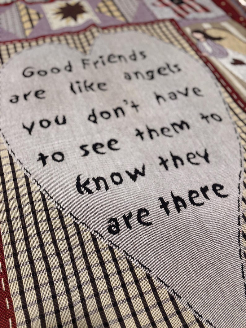 May include: A quilted fabric with the text "Good Friends are like angels, you don't have to see them to know they are there" in a heart shape. The background has a plaid pattern in shades of brown and cream.
