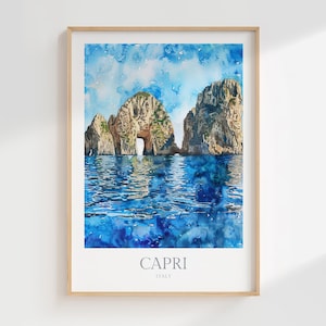 May include: A watercolour print of Capri, Italy, depicting the Faraglioni rocks rising from the blue sea. The artwork shows the natural archway and the surrounding water in shades of blue and white, framed in a light wood.