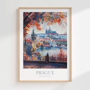 Op de afbeelding: Een aquarel schilderij van Praag, Tsjechië, met uitzicht op de stad vanaf een heuveltop. Het schilderij toont een stadsbeeld met een rivier, een brug en een groot kasteel op de achtergrond. Op de voorgrond is een weelderig groen park met bomen en een stenen muur.
