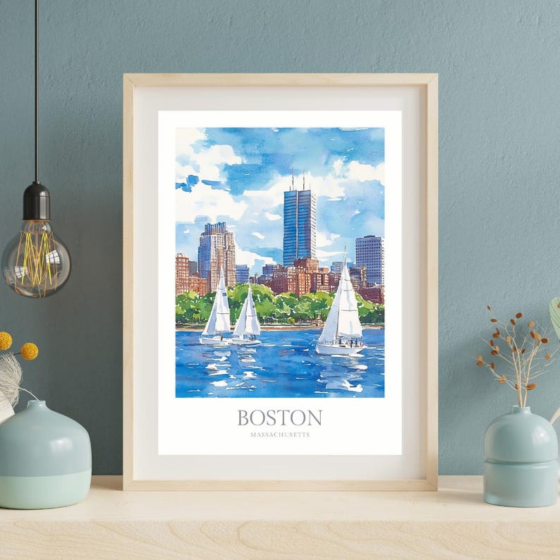 May include: A watercolor painting of the Boston skyline with sailboats in the water. The painting is framed in a light wood frame. The text "BOSTON MASSACHUSETTS" is printed below the image.