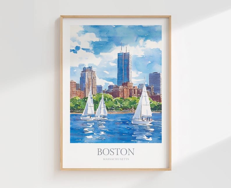 May include: A watercolor painting of the Boston skyline with sailboats in the water. The painting is framed in a light wood frame. The text "BOSTON MASSACHUSETTS" is printed at the bottom of the painting.