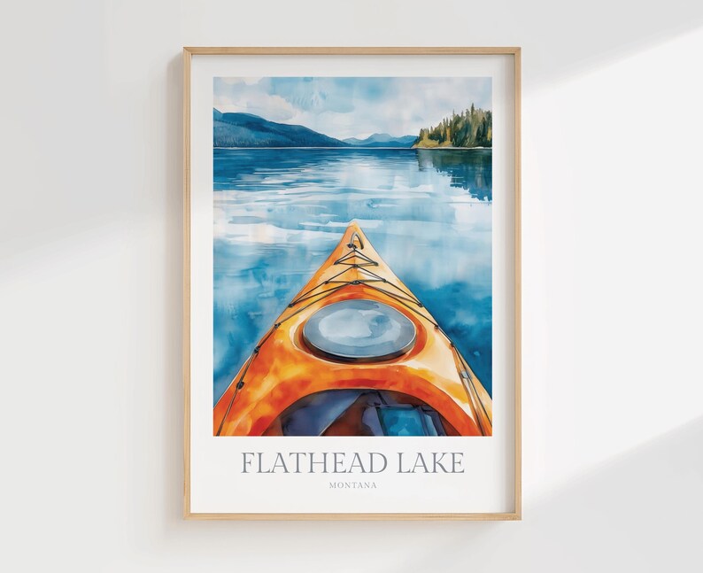 May include: A framed art print featuring a watercolor illustration of an orange kayak on blue water, with mountains and trees in the distance. The text at the bottom reads FLATHEAD LAKE MONTANA in a clean, sans-serif font against a white background.
