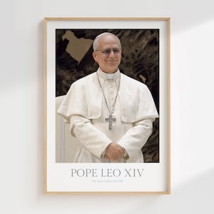 Può includere: Un ritratto incorniciato di Papa Leone XIV. L'immagine mostra un uomo in una veste papale bianca, con occhiali e una collana con croce d'argento. Il testo "POPE LEO XIV" e "IN ILLO UNO UNUM" è stampato in basso nel telaio.
