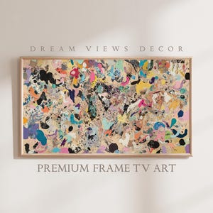 May include: Abstract art print with a colorful, swirling design in shades of pink, blue, yellow, green, and black. The print is framed in a light wood frame. "DREAM VIEWS DECOR" and "PREMIUM FRAME TV ART" are printed below the image.