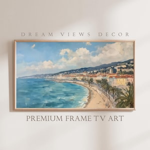 Pode incluir: Uma pintura emoldurada que retrata uma cidade costeira com um oceano azul, uma praia de areia e edifícios ao longo da costa. O céu é azul com nuvens brancas. A pintura está em uma moldura de madeira clara.
