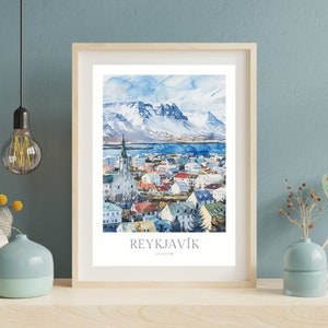 May include: A watercolor painting of Reykjavik, Iceland. The painting shows a cityscape with a church steeple, colorful buildings, and snow-capped mountains in the background. The text "REYKJAV&Iacute;K" and "ICELAND" is printed below the image.