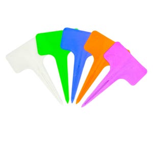 May include: A selection of brightly coloured plant labels in white, green, blue, orange, and pink. Each label has a T-shaped top for writing and a pointed stake for insertion into soil. These plastic markers are for garden use.