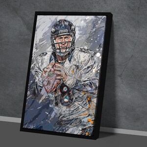 May include: Framed art print of a football player in a helmet, holding a football. The artwork features a color palette of white, blue, and orange, with a textured, abstract style. The player's jersey displays the number 18.