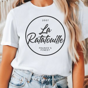 May include: White t-shirt with a black circle graphic that says "2007 La Ratatouille France's Finest"