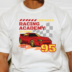 May include: White t-shirt with a red and yellow graphic of a red sports car with the text "Lightning's Racing Academy Ka-Chow Since 2006 95"