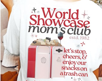 May include: White t-shirt with a red and black graphic design. The graphic features a red and white trash can with a cheese board and wine glass on top. The text reads "World Showcase mom's club estd. 1982 let's stop, cheers, & enjoy our snacks on a trash can but, let's not stop in the walkway"