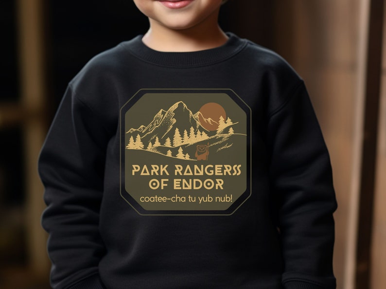 May include: A black sweatshirt with a green and brown patch featuring a mountain scene and the text "Park Rangers of Endor" with the phrase "coatee-cha tu yub nub!" underneath.