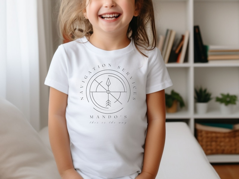 Puede incluir: Camiseta blanca con un dise&ntilde;o de br&uacute;jula en blanco y negro y el texto "Navigation Services Mando's This is the way".