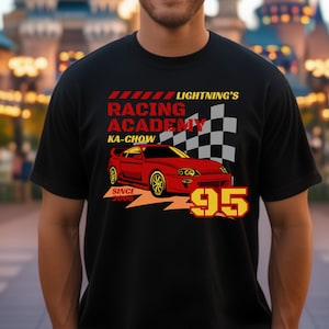 May include: Black t-shirt with a red and yellow graphic of a red sports car with the text "Lightning's Racing Academy", "Ka-Chow", and "95".