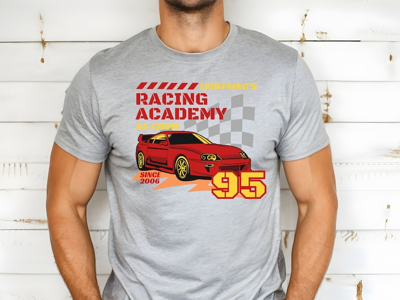 May include: A gray t-shirt with a red sports car graphic and the text "Lightning's Racing Academy #1 Crew Since 2006 95".
