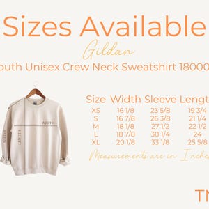 May include: A size chart for a youth unisex crew neck sweatshirt. The chart shows the size, width, sleeve length, and length in inches. The chart is for Gildan 18000B sweatshirts.