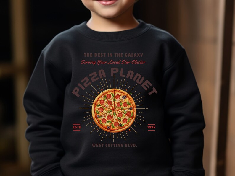 K&ouml;nnte beinhalten: Schwarzes Sweatshirt mit einem roten und wei&szlig;en Grafikdruck einer Pizza mit dem Text "Pizza Planet", "The Best in the Galaxy", "Serving Your Local Star Cluster", "Est. 1995" und "West Cutting Blvd."