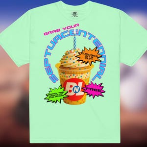 May include: A pale green t-shirt with a cupcake in a cup graphic and a lit candle. The shirt's text includes "Grab Your Septuacentenial" and "Cupcake in a Cup". Additional text reads "Happy 700 Years on the Axiom" and "Free".