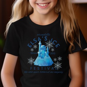 May include: Black t-shirt with a blue and white graphic design featuring a castle, snowflakes, and the text "Arendelle Elsa's Ice Festival Since 2013 The cold never bothered me anyway".