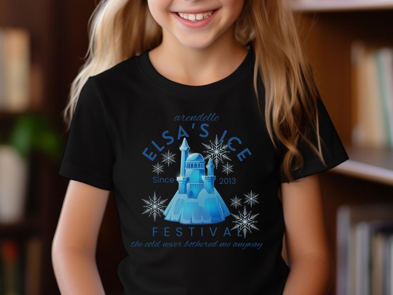 May include: Black t-shirt with a blue and white graphic design featuring a castle, snowflakes, and the text "Arendelle Elsa's Ice Festival Since 2013 The cold never bothered me anyway".