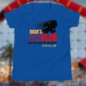 May include: Royal blue t-shirt with the text "Dash's Run Club" in yellow and red. A black silhouette of a running figure is above the text. The shirt also has the text "Why run when you can dash? 5-4-3-2-1... GO!"