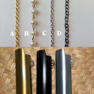 May include: Four vertical chains labelled A, B, C, and D, including a gold link chain, a pearl-accented gold chain, a silver link chain, and a dark metal link chain, positioned above three rectangular lighter cases in gold, black, and silver.