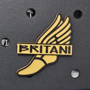 May include: A gold-colored winged foot logo with the word "BRITANI" in black lettering across the top.