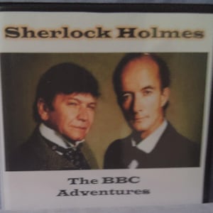 May include: A VHS tape featuring a black and white image of Sherlock Holmes and Dr. Watson. The text on the tape reads "Sherlock Holmes The BBC Adventures".