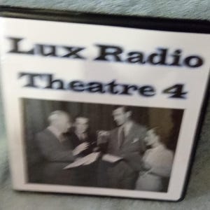 May include: A black and white DVD case with the text "Lux Radio Theatre 4" at the top. The case features a black and white photo of several people. The case is rectangular and has a black border.