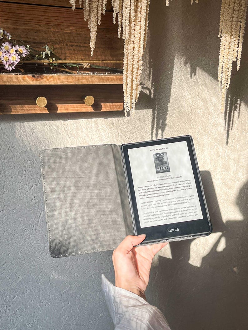 May include: A black and grey Kindle e-reader with a grey cover. The screen displays the text "NOW AVAILABLE!" and the title "Broken Heart" by  J.T.  Fox. The text on the screen reads: "When a cold-case killer targets Boston's elite, police officer  Detective  Ava  Bennett  finds herself in a race against time.  Ava  has a  favorite  TV  show  and  she  always  keeps  the  volume  low  so  she  can  hear  everything  including  the  murmurs  of  small  voices  coming  from  the  apartment  next  door.  Ava  is  living  the  predictable  life  she  always  dreamed  of.  But  when  a  cold-case  killer  targets  Boston's  elite,  Ava  finds  herself  in  a  race  against  time.  Ava  is  forced  to  confront  her  past  and  the  secrets  she  has  been  keeping  for  years.  Ava  is  a  strong  and  determined  woman  who  will  stop  at  nothing  to  protect  her  city  and  her  family.  Ava  is  a  detective  with  a  broken  heart  and  a  secret  that  could  destroy  her.  The  suspense  and  happening  are  magnificent.  The  writing  is  simple  and  compelling  and  your  imagination  will  keep  you  turning  the  pages.  This  is  a  must-read  for  any  fan  of  crime  fiction.  You  will  keep  you  on  the  edge  of  your  seat  with  every  twist  and  turn.  This  is  a  remarkable  book  that  you  have  to  read."