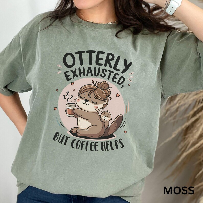May include: A green t-shirt with the text "Otterly Exhausted, But Coffee Helps" and a cartoon image of an otter holding a cup of coffee.