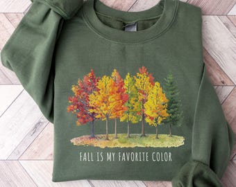 May include: Military green sweatshirt with a colorful fall tree design. The graphic features trees with red, orange, and yellow leaves, with the text "FALL IS MY FAVORITE COLOR".