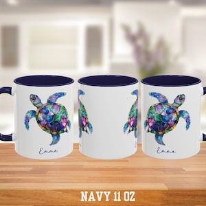 May include: White ceramic mug with a navy blue interior and handle. The mug features a colorful watercolor sea turtle design with the name "Emma" printed below. The text "NAVY 11 OZ" is printed at the bottom.