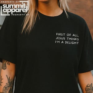 May include: A white ceramic mug with a black handle and the text "But First, Coffee" in a bold, black font. The mug is set against a blurred background, suggesting a cozy setting. The mug appears to be approximately 4 inches tall.