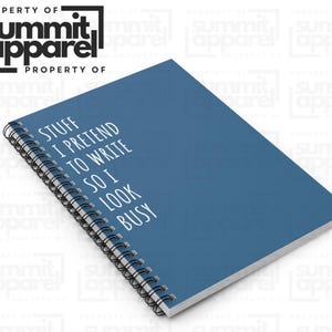 May include: A blue notebook with a black spiral binding. The white text on the cover reads "STUFF I PRETEND TO WRITE SO I LOOK BUSY." The logo "summit apparel" is in the upper left corner.