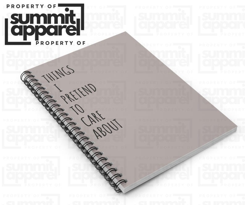 May include: A grey spiral-bound notebook with the text "THINGS I PRETEND TO CARE ABOUT" in black. The notebook is from Summit Apparel.