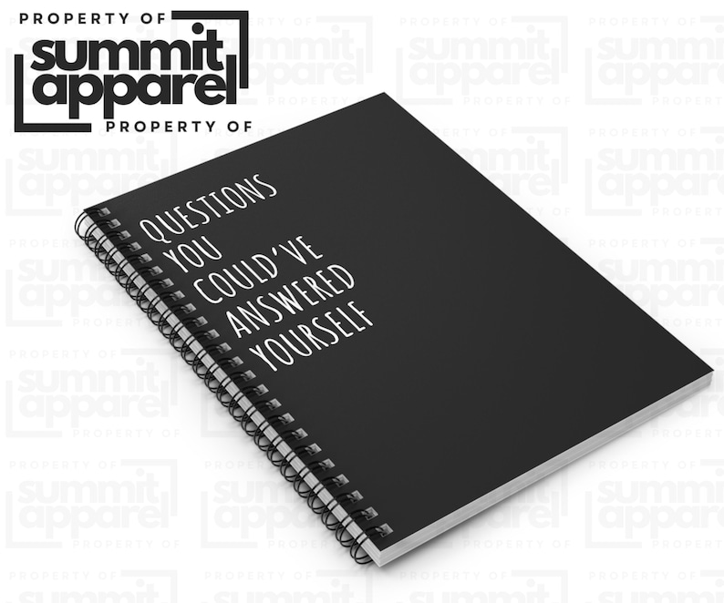 May include: A black notebook with a spiral binding, featuring the white text "QUESTIONS YOU COULD'VE ANSWERED YOURSELF". The notebook is from Summit Apparel. The cover is visible, with the spiral binding along the left edge.