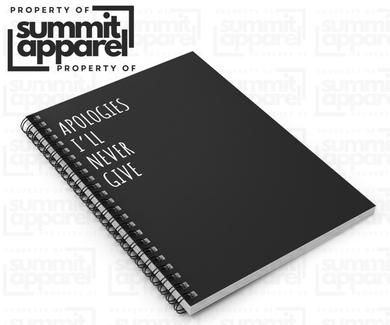 May include: Black spiral-bound notebook with the text "APOLOGIES I'LL NEVER GIVE" in white. The notebook has a black cover and white pages. The Summit Apparel logo is in the top left corner.