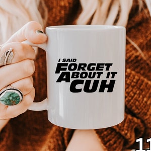 May include: White ceramic mug with black text that reads "I said forget about it, Cuh". The mug is 11 ounces.